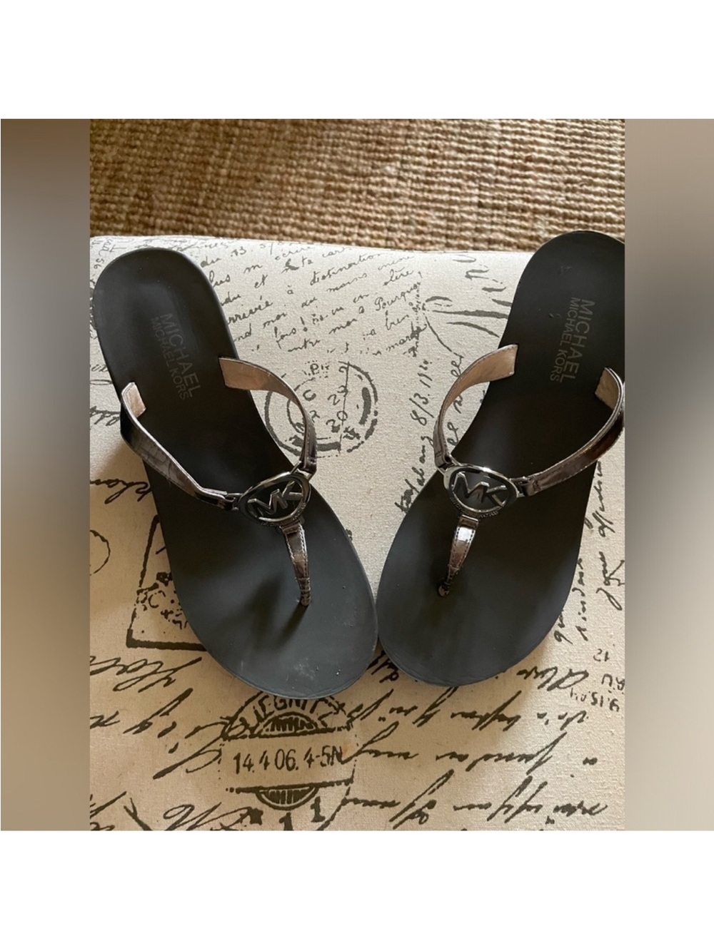 Michael Kors wedge thong sandals featuring a silver metallic MK logo emblem